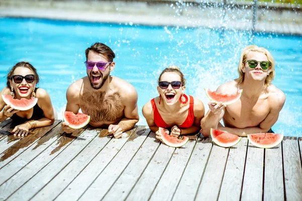 Amis avec pastèque sur la piscine en plein air — Photo