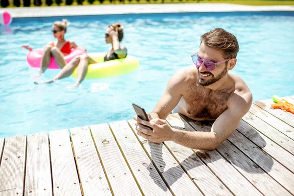 Homme avec téléphone dans la piscine — Photo