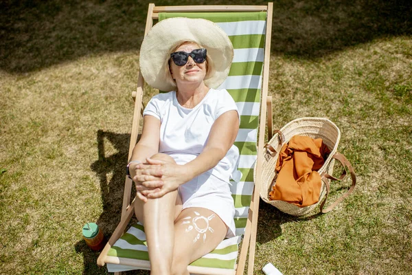 Oudere vrouw op de zonnebank buiten — Stockfoto