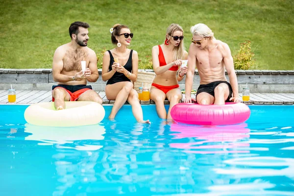 Group of friends with sunscreen lotion on the swimming pool — Fotografia de Stock