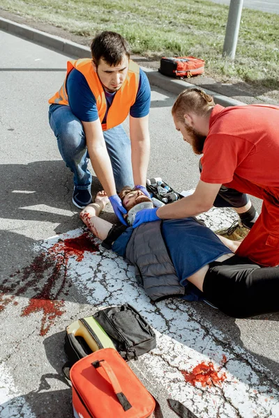 Sürgősségi ellátásban részesítik a sérültet az úton. — Stock Fotó
