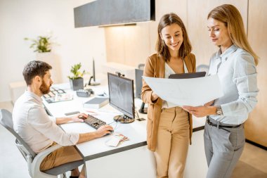 Ofiste bir mimari projeyle çalışan meslektaşlar.