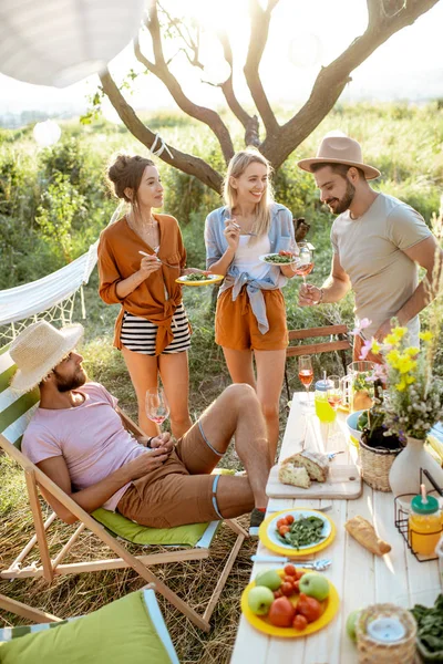 Dostlar bahçede şenlikli bir öğle yemeği yerken — Stok fotoğraf