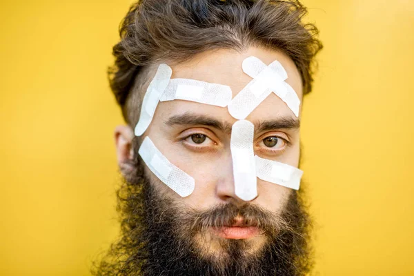 Man with medical patches on his face — Stock Photo, Image