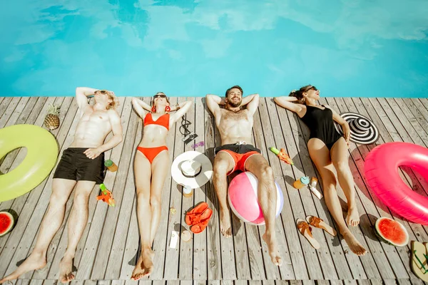 Amigos banhos de sol na piscina — Fotografia de Stock