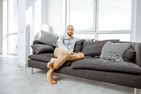 Man on the couch at home — Stock fotografie