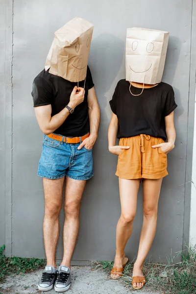 Мужчина и женщина с бумажными пакетами на голове — стоковое фото