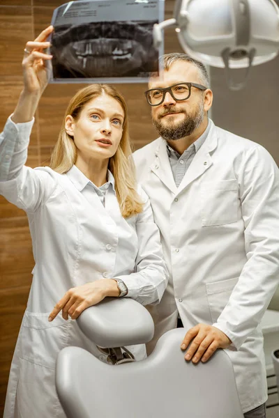 Dentists examining x-ray image at the office — Stock Photo, Image