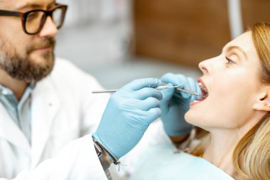 Diş muayenehanesinde dişçi muayenesi sırasında kadın.