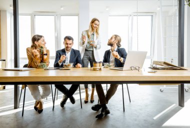 Ofis çalışanı iş başında yemek yiyor.
