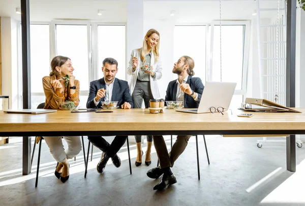 Kontorsarbetare som äter på arbetet — Stockfoto