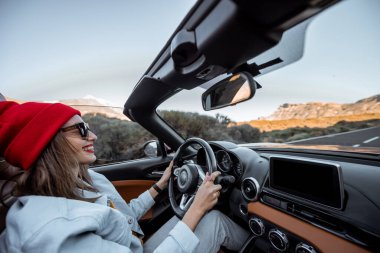 Çölde Cabriolet arabasıyla seyahat eden bir kadın.