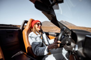 Çölde Cabriolet arabasıyla seyahat eden bir kadın.