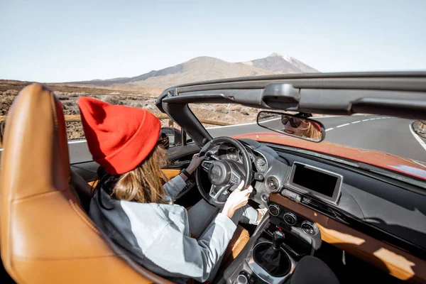 Woman traveling by cabriolet car on the desert road — Stock Photo, Image