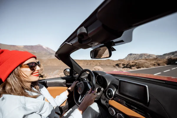 Woman traveling by cabriolet car on the desert road — Stock Photo, Image