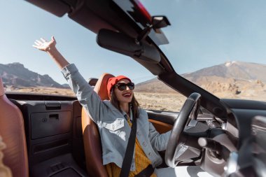 Çölde Cabriolet arabasıyla seyahat eden bir kadın.