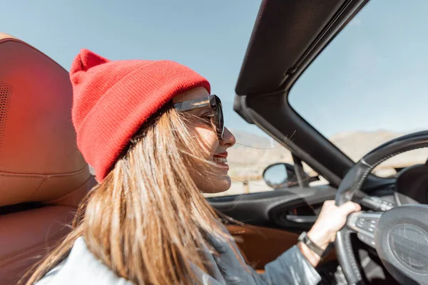 Жінка подорожує на кабріолетній машині на пустельній дорозі — стокове фото