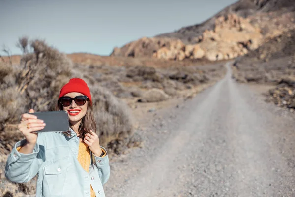 Woman vlogging while travel on the desert valley — Stockfoto