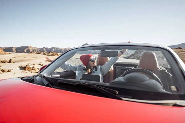 Woman traveling by cabriolet car on the desert velley — Zdjęcie stockowe