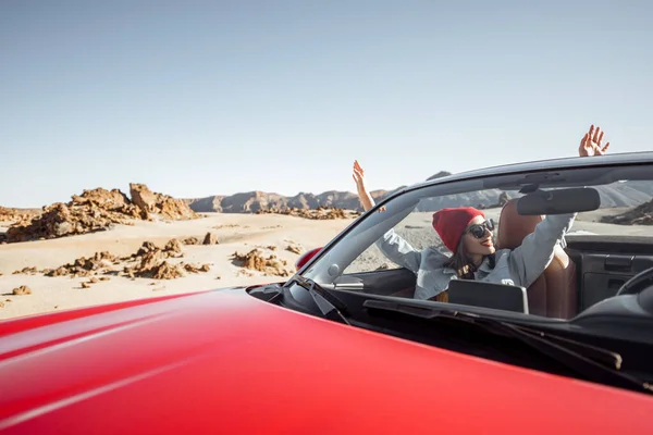 Woman traveling by cabriolet car on the desert velley — Zdjęcie stockowe