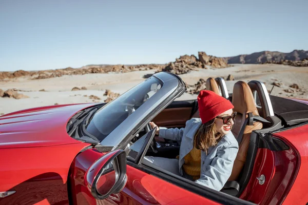 Woman traveling by cabriolet car on the desert velley — Stockfoto