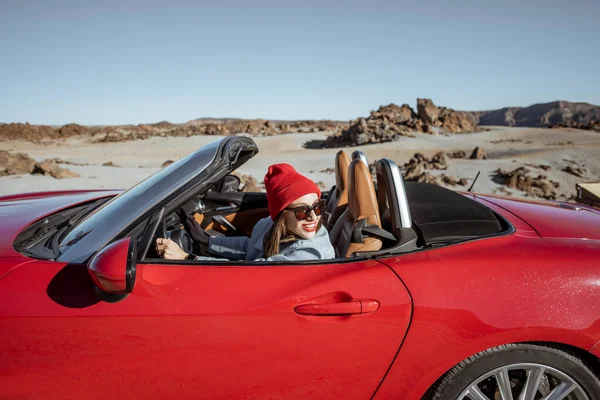Woman traveling by cabriolet car on the desert velley — Stockfoto