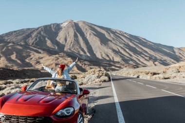 Volkanik vadide arabayla seyahat eden bir kadın.