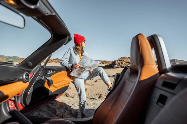 Woman traveling by cabriolet car on the desert valley — Stockfoto