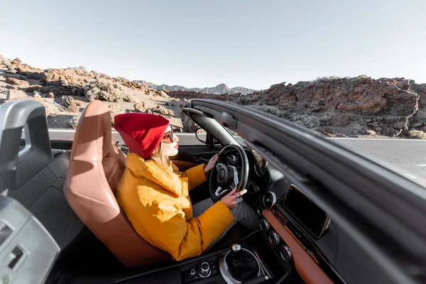 Kobieta podróżująca kabrioletem na pustynnej drodze — Zdjęcie stockowe