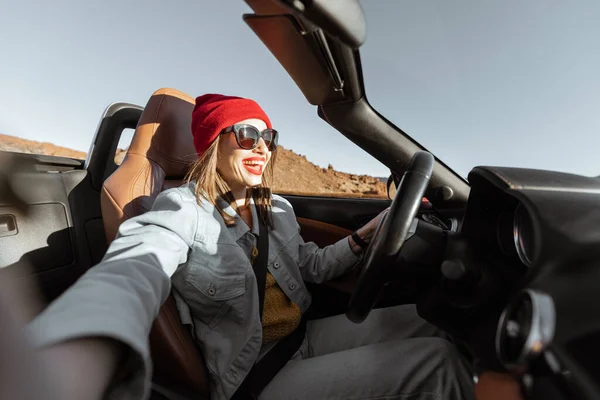 Жінка подорожує на кабріолетній машині на пустельній дорозі — стокове фото