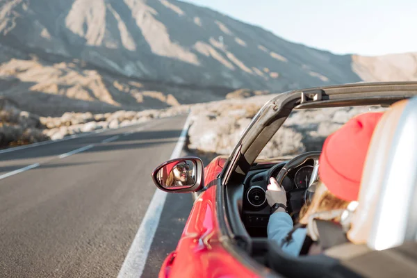 Woman driving convertible car on the desert road — Zdjęcie stockowe