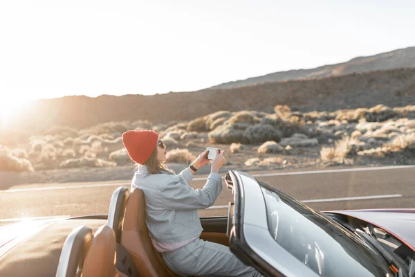 Безтурботний жінка подорожує на машині на пустельній дорозі — стокове фото