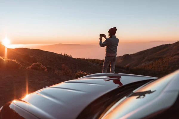 Woman enjoying beautiful sunset while traveling in the mountains by car — Stok fotoğraf