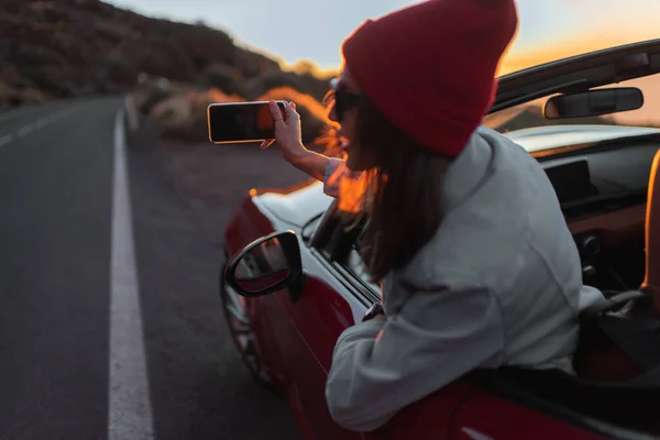 Woman traveling by car on a beautiful road during a sunset — Φωτογραφία Αρχείου