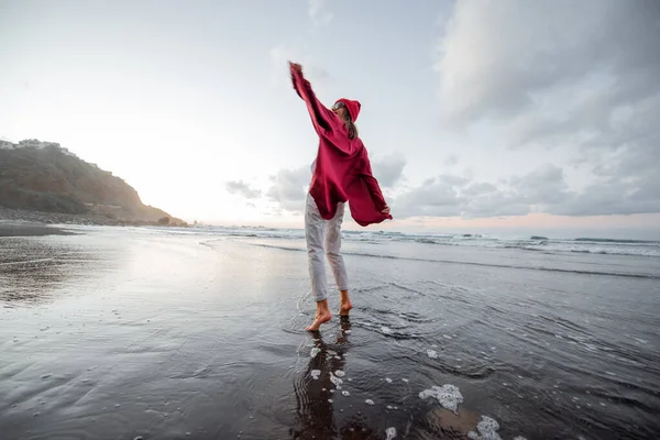 Lifestyle portrait of a carefree woman on the beach at dusk — Stockfoto