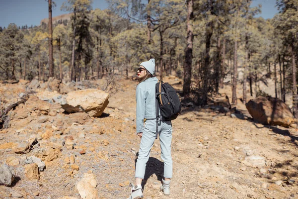 Mujer senderismo en el bosque muy en las montañas en una roca volcánica —  Fotos de Stock