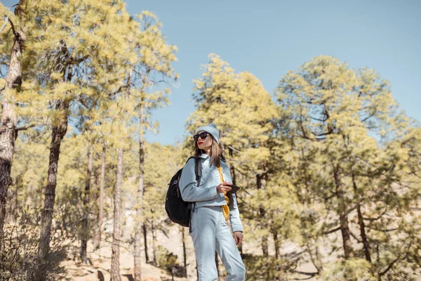 Mujer senderismo en el bosque muy en las montañas en una roca volcánica — Foto de Stock