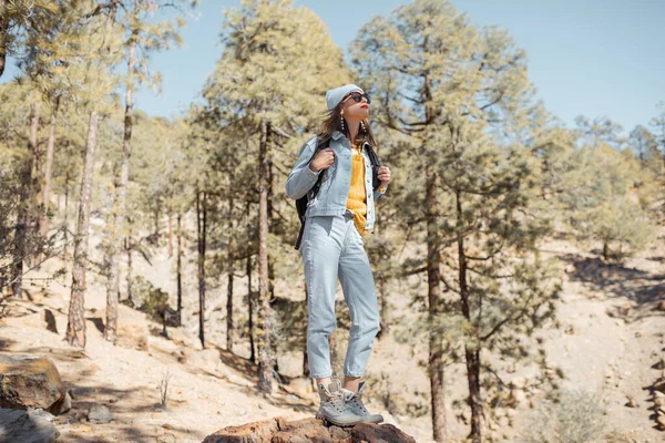 Mujer senderismo en el bosque muy en las montañas en una roca volcánica — Foto de Stock