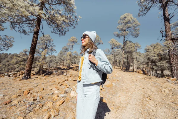 Woman hiking in the forest highly in the mountains on a volcanic rocks — Stock Photo, Image