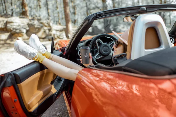 Woman traveling by car in the forest — ストック写真