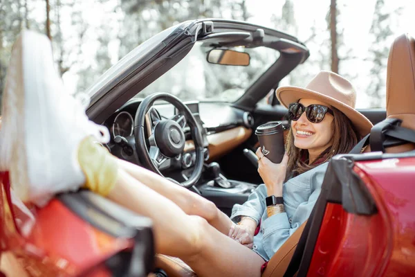 Carefree woman tarveling by car in nature — Stockfoto