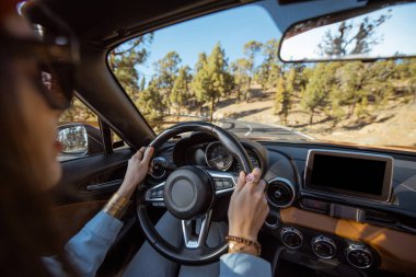 Woman driving a cabriolet on the mountain road