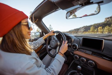 Woman driving a cabriolet on the mountain road