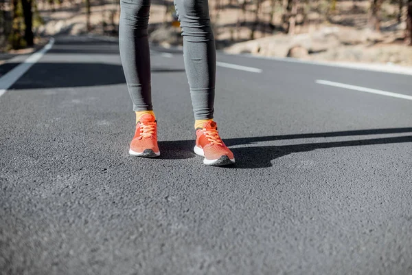 Sports woman in running shoes on the road — 图库照片