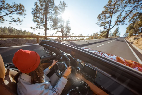 Mulher dirigindo um cabriolet na estrada da montanha — Fotografia de Stock