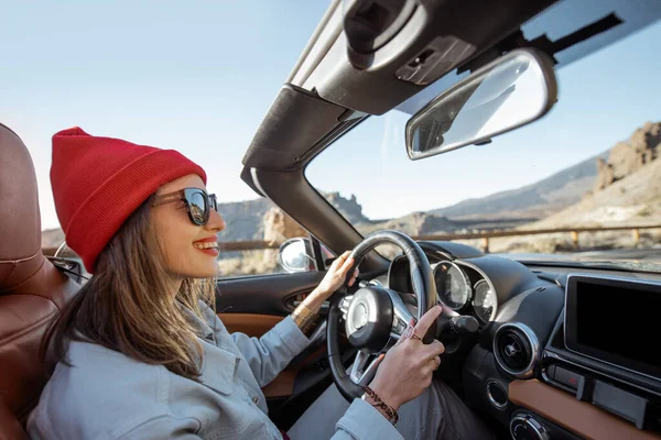 Woman traveling by cabriolet on the desert road — Stock Photo, Image