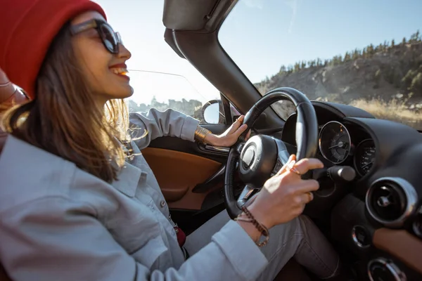 Woman driving a cabriolet on the mountain road — Stock fotografie