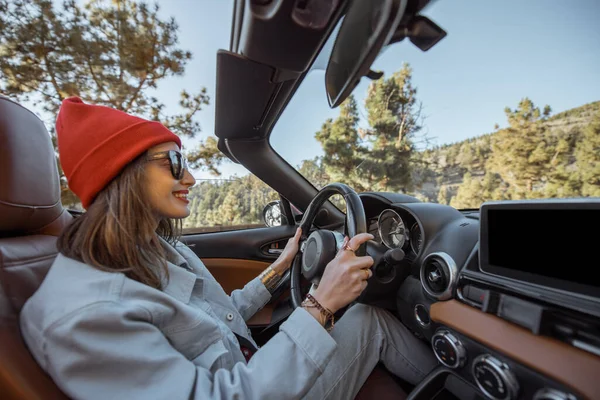 Woman driving a cabriolet on the mountain road — Stockfoto