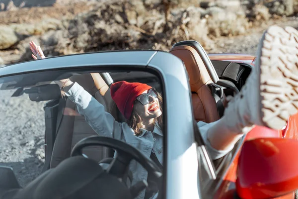 Kvinna reser med cabriolet bil på öknen dalen — Stockfoto