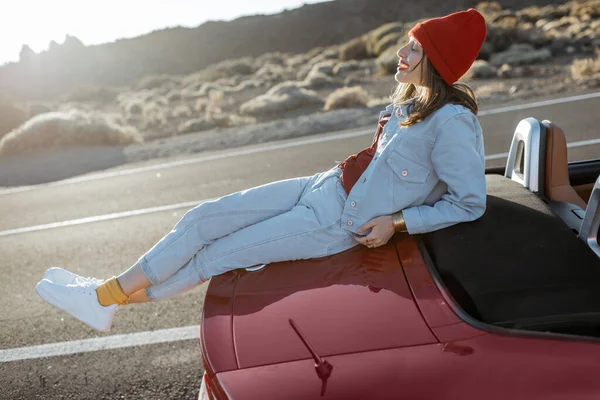 Woman traveling by car on a desert valley — Stockfoto